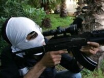 A masked militant of the Shi'ite Amal militia holds a position during heavy clashes with pro-government fighters in the Druze mountains southeast of Beirut on May 11 (AFP)