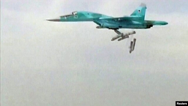 A still image taken from video footage and released by Russia's Defence Ministry on August 18 shows a Russian Sukhoi Su-34 fighter bomber based at Iran's Hamadan air base dropping bombs in the Syrian province of Deir ez-Zor.