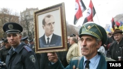 Members of a World War II guerrilla movement, the Ukrainian Insurgent Army (UPA), hold a portrait of UPA leader Stepan Bandera in Kyiv.