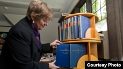 Dean Martha Roth, the editor-in-charge of the Assyrian dictionary, places the final volume to be completed among the others. (photo: University of Chicago -- Jason Smith)