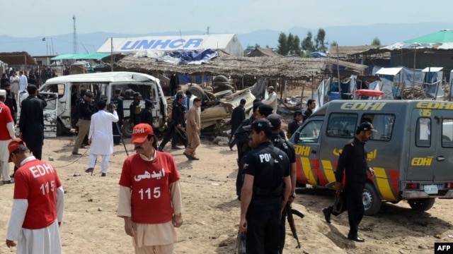 Pakistani security and medical personnel are pictured at the site of a car-bomb attack at the Jalozai refugee camp near Peshawar on March 21.