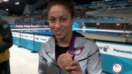 Elizabeth Stone shows one of her bronze medals during the victory ceremony in London in August.