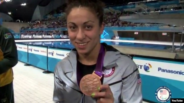 Elizabeth Stone shows one of her bronze medals during the victory ceremony in London in August.