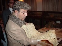 The former culture minister, Sayyed Makhdum Rahin, examines a Sultani artifact (RFE/RL)