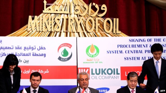 Iraqi Oil Minister Abdelkarim al-Luaybi (center) sits between LUKoil Mideast's chief, Iskander Nasyrov (left), and Samsung Vice President Park Ki-Seok (right) as they sign a $1 billion deal to develop Iraq's second-biggest oil field in Al-Basrah in March.
