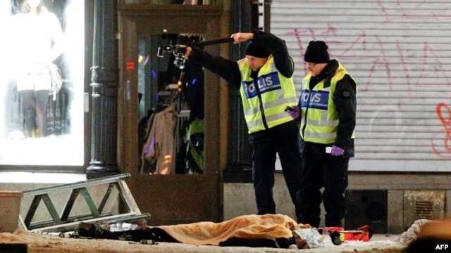 Police forensics experts examine the remains of a suspected suicide bomber in Stockholm.