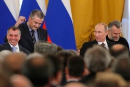 Ресей президенті Владимир Путин (оң жақтан екінші) Қырым "премьер-министрі" Сергей Аксенов (оң жақтан үшінші) пен Қырым парламентінің "спикері" Владимир Константиновқа қарап тұр. Мәскеу, 18 наурыз 2014 жыл.