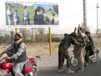 An Afghan soldier searches passengers at a checkpoint in Arghandab district (AFP