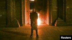 Russian artist Pyotr Pavlensky stands in front of the Federal Security Service (FSB) headquarters in central Moscow shortly after he had set fire to one of the building's doors.