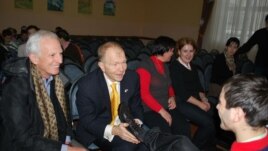 Ambasadorul american William H. Moser încălțînd copii la Școala internat nr. 5 din Chişinău.
