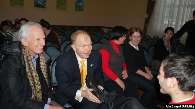Ambasadorul american William H. Moser încălțînd copii la Școala internat nr. 5 din Chişinău.