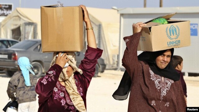 Syrian refugees carry aid and rations at the Zaatari refugee camp in the city of Mafraq, Jordan. (file photo)