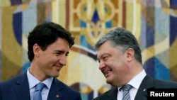 Ukrainian President Petro Poroshenko (left) talks with Canadian Prime Minister Justin Trudeau during a signing ceremony for a trade deal, in Kyiv on July 11.