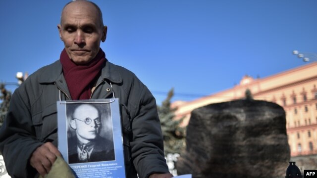 Сталиндік қуғын-сүргін құрбаны болған әкесінің суретін ұстап тұрған азамат. Мәскеу, 29 қазан 2014 жыл. 