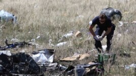 Эксперт работает с обломками MH17 на месте падения