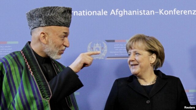 German Chancellor Angela Merkel (right) talks with Karzai in Bonn on December 5.