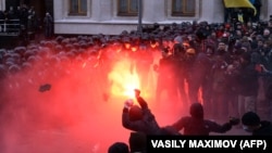 Protesters clash with riot policemen outside the Ukrainian President's office in Kyiv.
