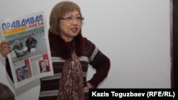 Розлана Таукина, редактор "Правдивой газеты", показывает в суде один из номеров издания. Алматы, 10 февраля 2014 года.