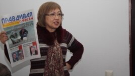 Розлана Таукина, редактор "Правдивой газеты", показывает в суде один из номеров издания. Алматы, 10 февраля 2014 года.