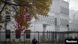 A policeman stands guard in front of the U.S. embassy in Sarajevo, which was attacked last October.