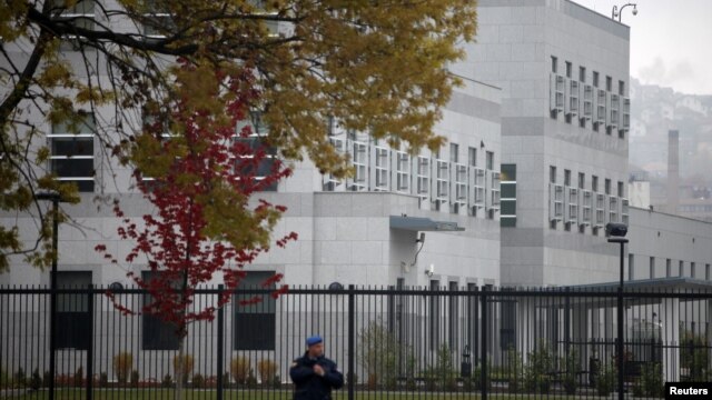 A policeman stands guard in front of the U.S. embassy in Sarajevo, which was attacked last October. 