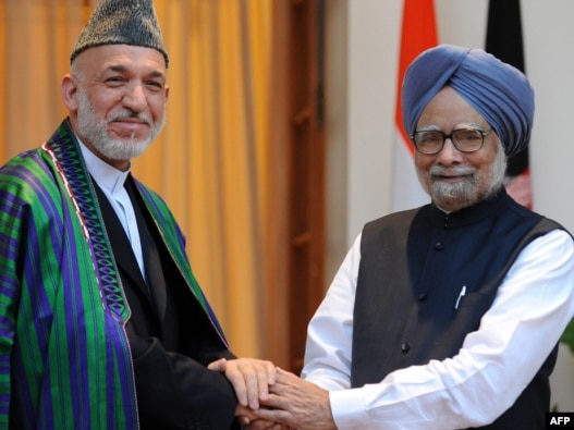 Indian Prime Minister Manmohan Singh (right) welcomes Afghan President Hamid Karzai to New Delhi on October 4.