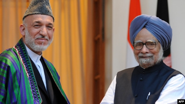 Indian Prime Minister Manmohan Singh (right) welcomes Afghan President Hamid Karzai to New Delhi on October 4.