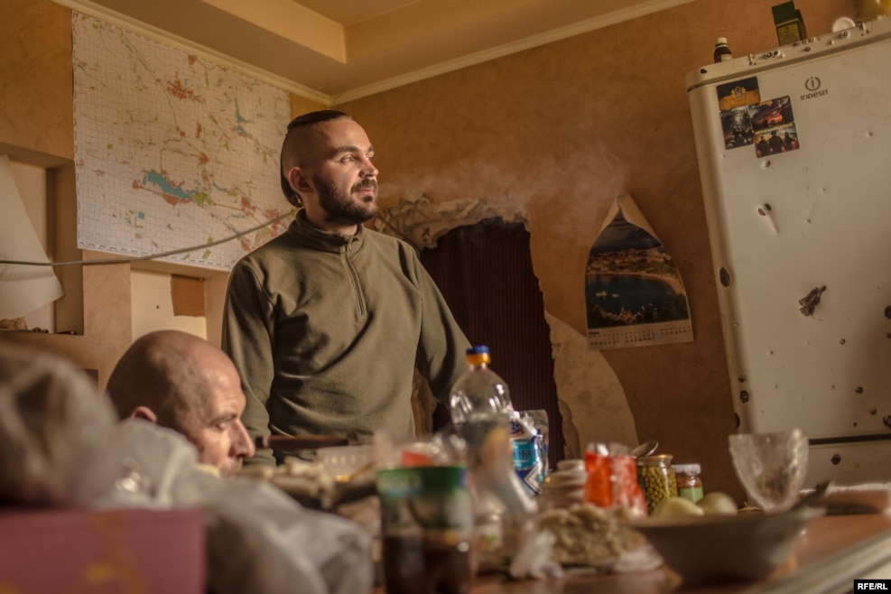 A soldier who goes by the nom de guerre "Nestor" stands in the kitchen. A native of Russia, Nestor's decision to fight on the Ukrainian side may be unusual, but is not unheard of.