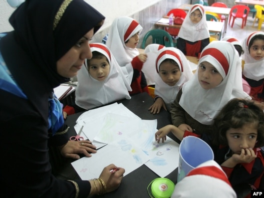 Girls gather around their teacher in a classroom in Tehran.