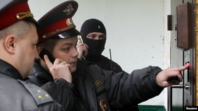 Russian Interior Ministry officers enter the building where opposition leader Sergei Udaltsov lives during a search operation in Moscow on October 17.