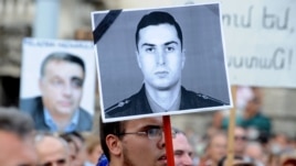 Hungary -- Activists and sympathizers of Hungarian 'Milla' Group lift a photo of Armenian Army Lieutenant Gurgen Margarian (C), beside a picture of Hungarian Prime Minister Viktor Orban (L), in front of parliament building in Budapest, 04Sep2012