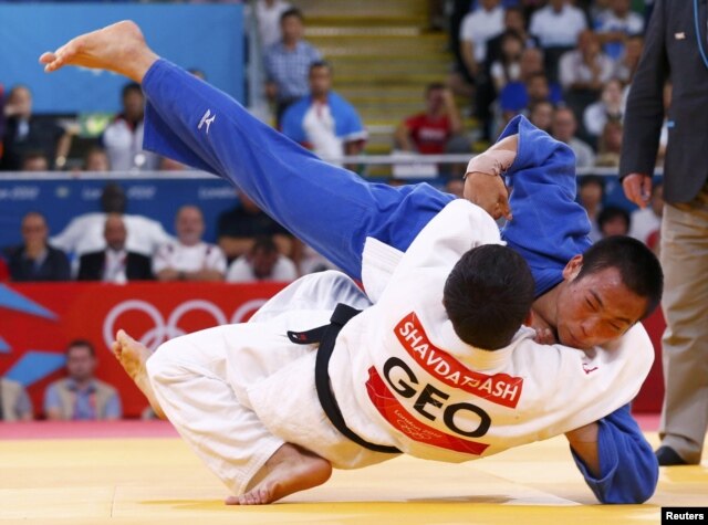 Georgia's Lasha Shavdatuashvili fights with Japan's Masashi Ebinuma (in blue) during their men's 66-kilogram semifinal B judo match on July 29. Shavdatuashvili took home gold.