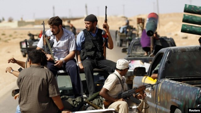 Rebel fighters patrol the town of Abu Grein, some 128 kilometers west of Sirte, on August 29.