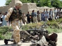A British soldier next to the wreckage of a car used in a suicide attack on May 21 (epa)