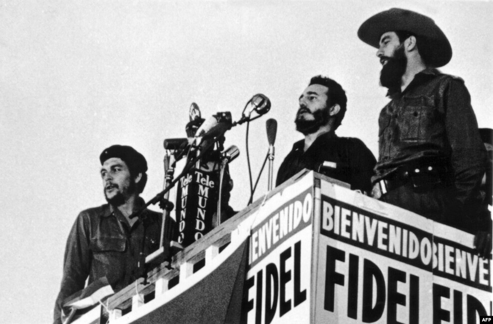 Castro (center) delivers a speech in Havana in 1959. Fellow revolutionaries Camilo Cienfuegos (right) and Ernesto Che Guevara (left) stand beside him. 