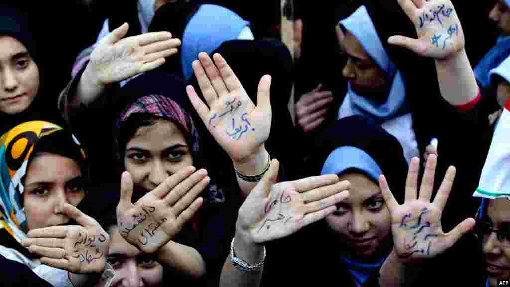 NOVEMBER 2, 2012 -- Iranian students show their palms, which read in Persian, "Crazy of Martyrdom," "Nuclear Scientist," "Death to America," and "I Sacrifice My Life For the Leader" outside the former U.S. Embassy in Tehran during a rally to mark the 33rd anniversary of the seizure of the U.S. Embassy and 52 diplomats by Islamist students. (AFP/Atta Kenare)
