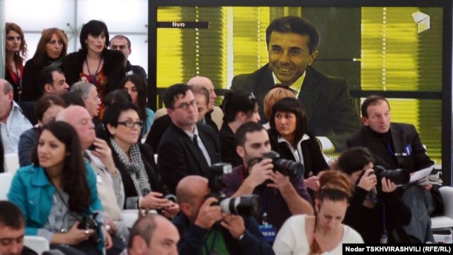 Reporters follow a Tbilisi press conference by billionaire businessman Bidzina Ivanishvili, who is seen on a big screen in the background, on November 1.