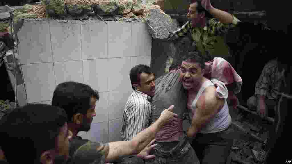 Crowds help rescue a man who was trapped in the rubble of the Nur al-Shuhada mosque after it was shelled by governnment forces in Aleppo, Syria, on October 17. (AFP/Fabio Bucciarelli)