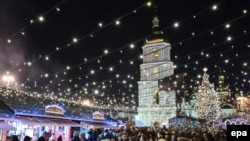 Ukraine -- Visitors walk across the Christmas market in front of the St. Sophiya Cathedral in Kiev, Ukraine, 28 December 2014.