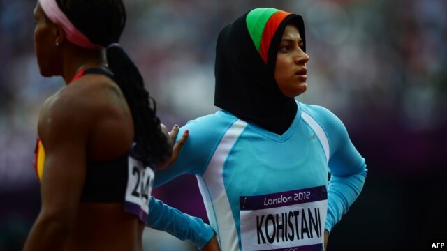 Afghanistan's Tahmina Kohistani (right) reacts after competing in the women's 100-meter heats at the athletics event during the London 2012 Olympic Games.