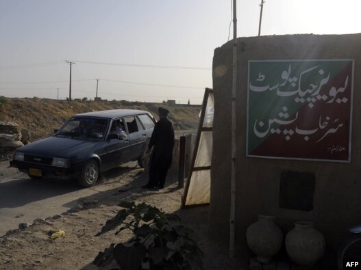 A Pakistani security officer searches a car at a checkpoint in Pishin, Baluchistan, in July 2011.