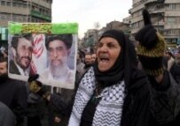 A woman holds a poster of Iranian President Ahmadinejad (left) and Supreme Leader Ayatollah Ali Khamenei (file photo) (epa)