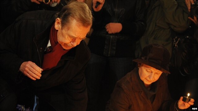 Former President Vaclav Havel lights a candle at a memorial in downtown Prague on November 17 to students whose protests launched the ouster of communism in 1989.