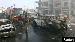 Syrian soldiers inspect the site of two bomb blasts in the government-controlled city of Homs on February 21.