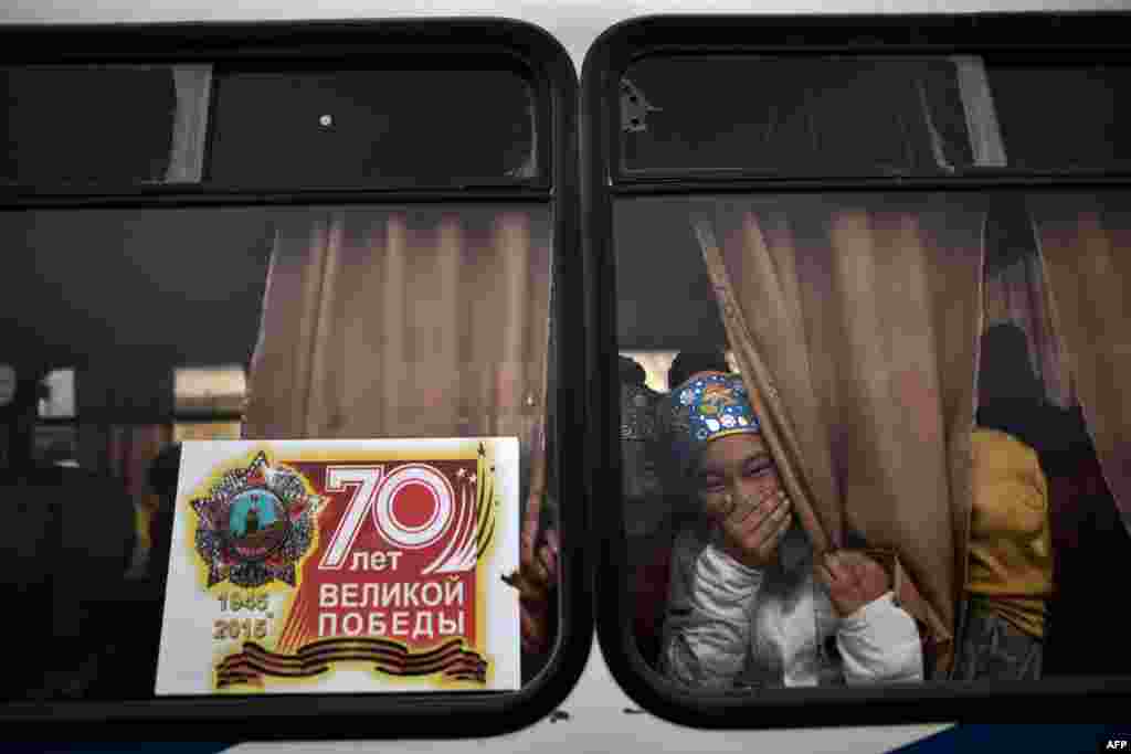 Young actresses laugh as they look out a window while they prepare to perform in the city of Baikonur to celebrate Maslenitsa (Shrovetide), a farewell ceremony for winter. Shrovetide precedes the beginning of Lent, with each day of the week holding its own meaning. Shrove Sunday, also known as the Sunday of Forgiveness, is a day for asking forgiveness for the harm caused to other people, intentionally or unintentionally. (AFP/Kirill Kudryavtsev)