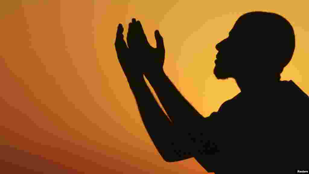 A man raises his hands to pray near the sea at sunset after a day of fasting in the holy month of Ramadan in Benghazi, Libya, on July 24. (REUTERS/Esam Al-Fetori)