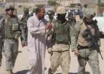 An Iraqi man (second from left) speaks with Iraqi and U.S. troops today in Tal Afar