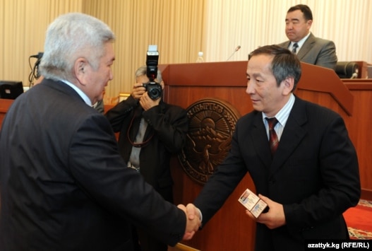 The chairman of the Central Election Commission, Akylbek Sariev (right), distributed documentation to deputies, including Ar-Namys leader Feliks Kulov.
