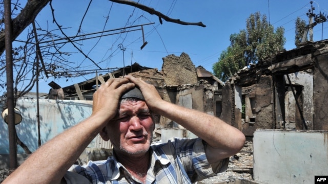 An ethnic Uzbek man stands beside the wreckage of his burned-out home in Osh on June 14, 2010.