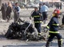 Iraq -- Firefighter working on burned remains of a car used by a suicide bomber. 4 Jan 2006